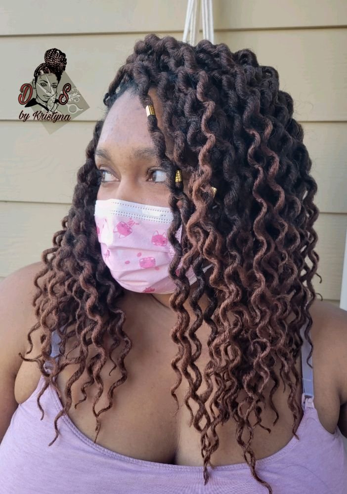 Crochet style with long voluminous curly hair in a dark brown and auburn blend with gold cuffs, front view