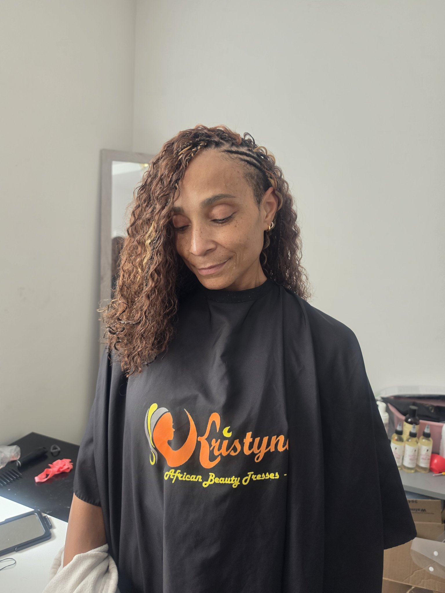Client wearing a Kristyna African Beauty Tresses cape with side braids and loose curls